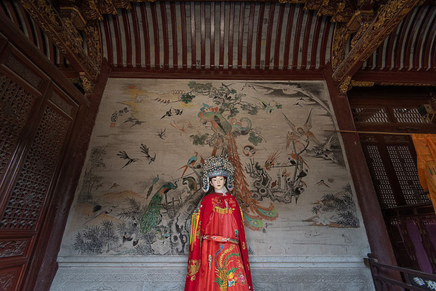 statue of cao e in front of ancient chinese print