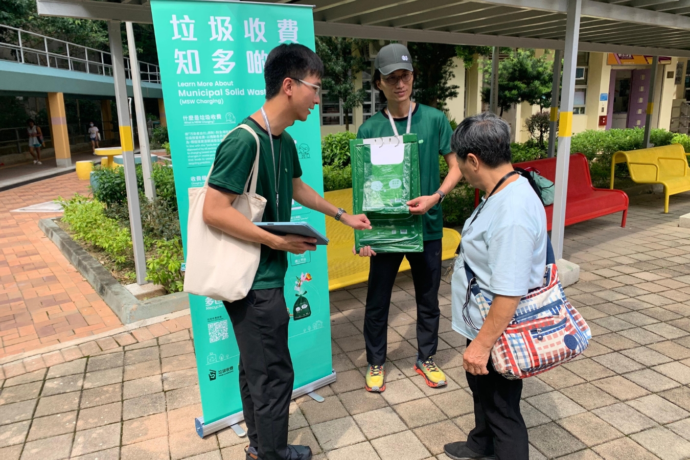 hong kong government workers talking to a resident about the waste-charging scheme