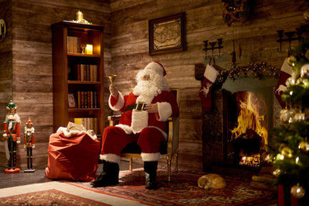 santa sitting on a couch beside a christmas tree at a meet santa event in hong kong