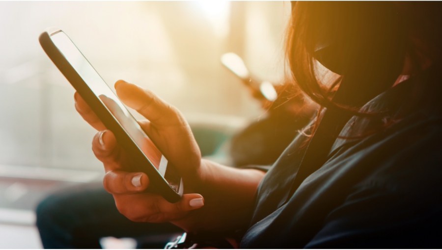 woman holding a phone and supporting the base of the phone with her pinky